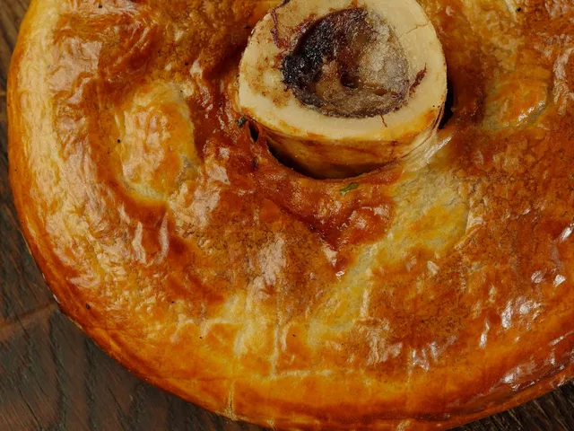 A deep-golden brisket and black pepper pie with a glossy, peppery filling visible through a cut top.