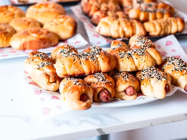 Golden vegetarian sausage rolls filled with cashew, mushroom and leek, on baking paper.